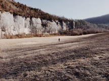 Person walking alone along a deserted prairie.