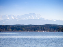 sailboats on a lake with mountains in the background 