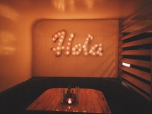 hola sign and candles on a booth table 