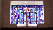 church interior with stained glass window and cross at the altar 