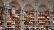 Paris, France - March 19, 2024: The Salle Ovale at the Bibliothèque Nationale de France, Richelieu an elegant oval room wood-paneled walls and beautiful ceiling, adorned with valuable book collection