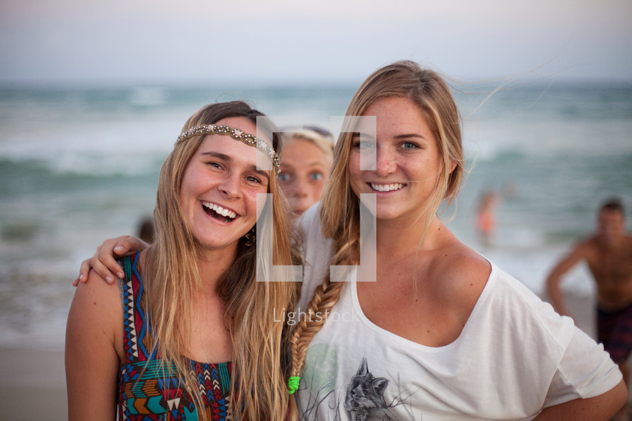 smiling and happy teen girls on a beach 