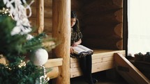 a girl reading a Bible in a cabin at Christmas 