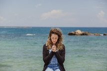 woman in prayer at the coast in Greece
