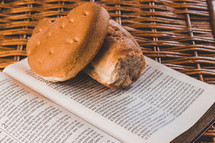 broken bread on the pages of a Bible in a basket 