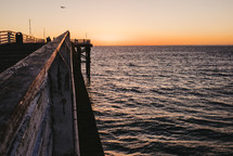 an ocean pier at sunset 