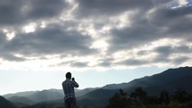 a man standing on a mountaintop praying 