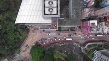 Aerial drone view of the building with fans on the rooftop. Traffic down below. Hong Kong Island.