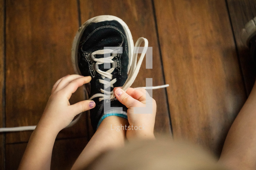child tying his shoe 