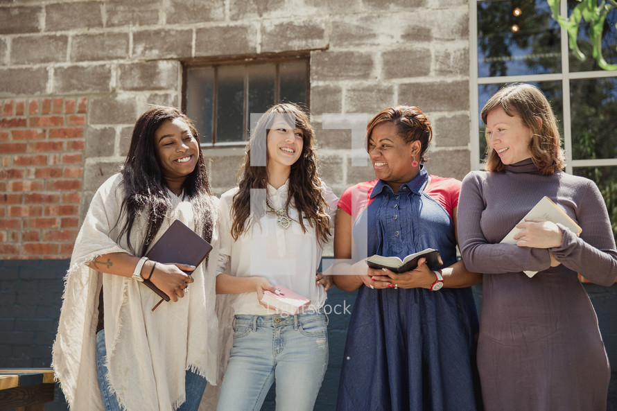 woman's group holding Bibles outdoors 