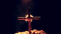 dust swirling around a wooden cross 