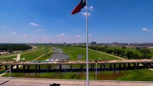 Texas flag on a flagpole flying over a bridge 