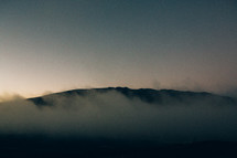 fog rising over a mountain 