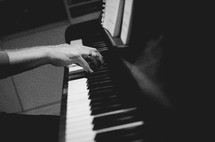 a man playing a chord on a piano