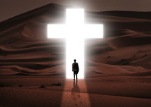 a man walking towards a glowing cross in the desert 