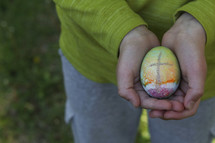 cupped hands holding an Easter egg 