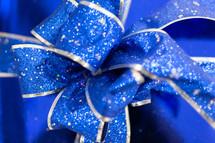 Blue ribbon bow with glitter on blue gift