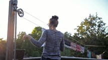 a woman putting clothes on the clothes line 