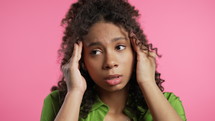 Portrait of beautiful suffering african woman having headache, pink studio portrait. Pretty lady putting hands on head. Concept of migraine problems, medicine, illness, magnetic storms concept. 