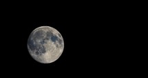 Full moon moving in the sky seen with telescope
