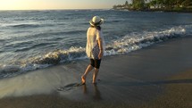 A woman walking on the ocean shore