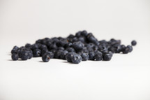 A group of blueberries spread out on white