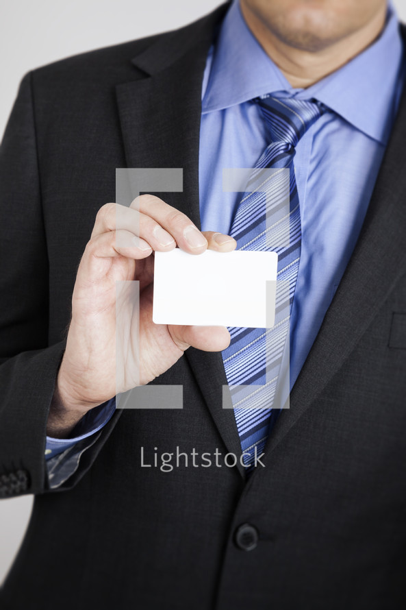 businessman holding up a blank business card 