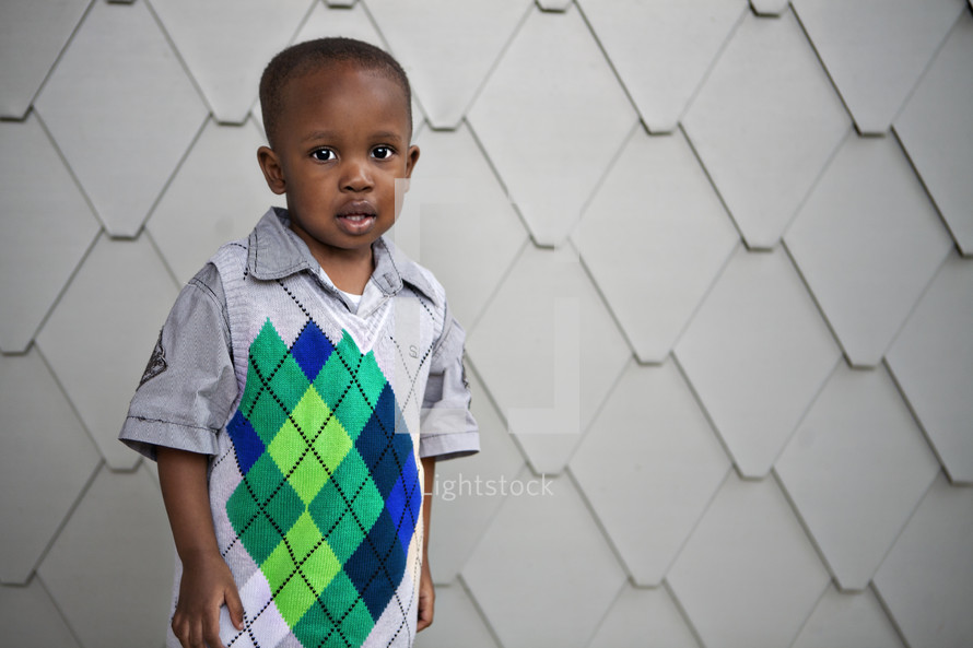 Boy posing in front of wall