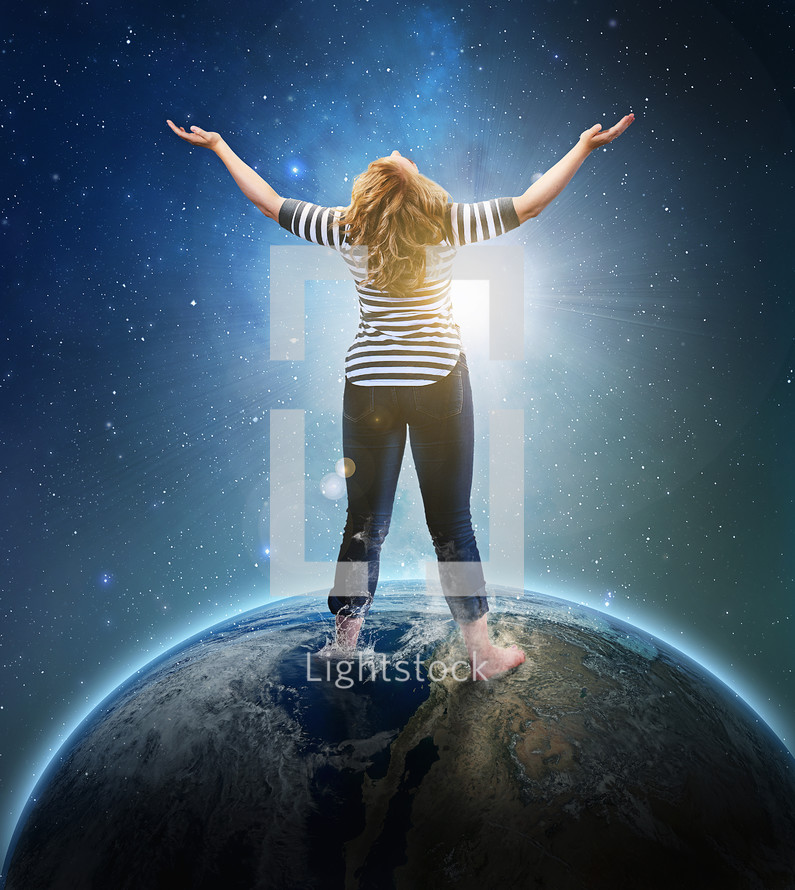 woman standing on top of the world with her arms raised in worship to God