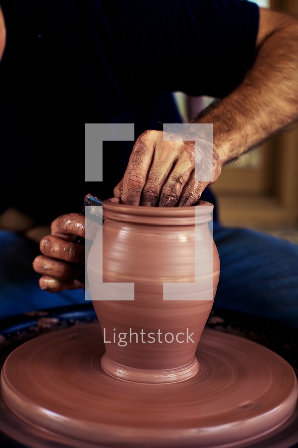 A man molding a pot on a potter's wheel