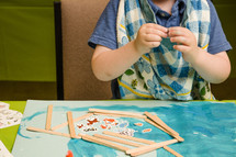 toddler with glue and paper at VBS 