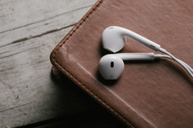 ear buds resting on a Bible