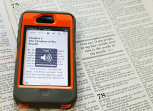 Bible verse on a cellphone lying on the pages of a Bible - please silence your cell phone message for church