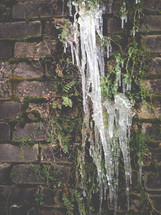 icicles hanging from a brick wall 