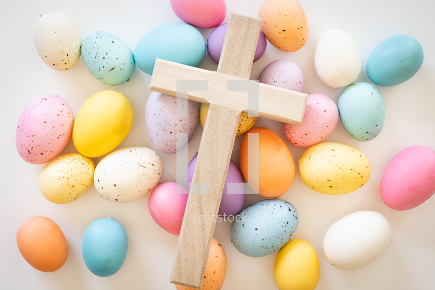 Wood cross on a background of easter eggs