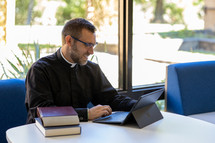 Pastor studying in front of a window