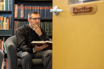Priest studying in a library