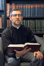 Priest studying in a library