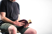 man sitting reading a Bible 