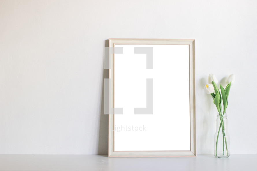 blank frame and vase with tulips 