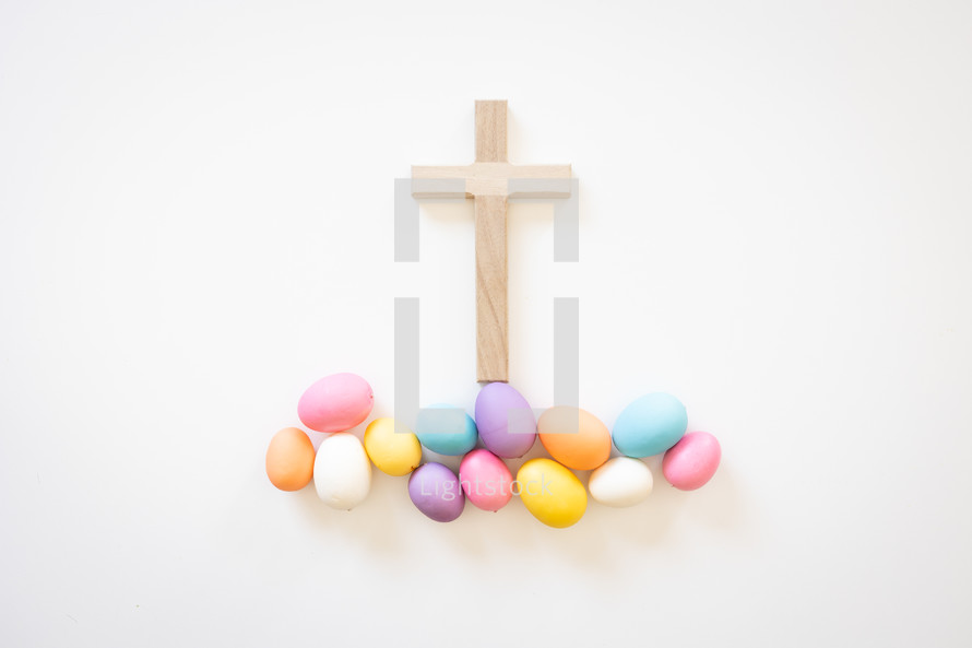 Wood cross with easter eggs on white background