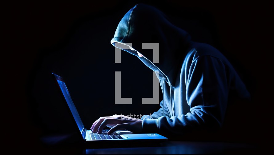 Hooded hacker stealing information from a laptop computer.