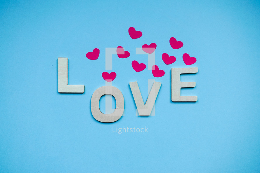 love wooden letters and heart shape on the blue background, feelings and emotions