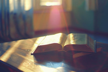 Open bible in sunlight on desk