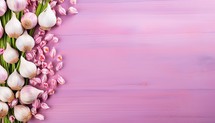 Garlic and tulip flowers on pink wooden background. Top view