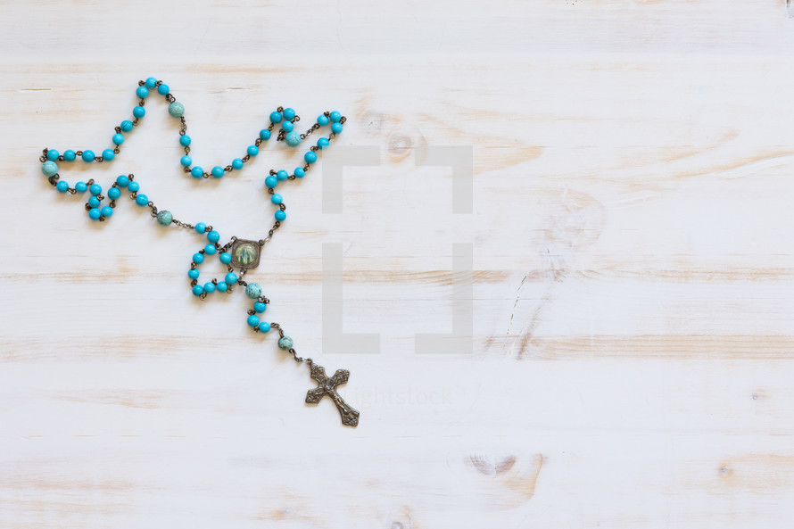 rosary on a white wood background 