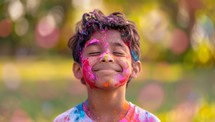Indian boy covered in colorful powder celebrating the Hindu holiday Holi