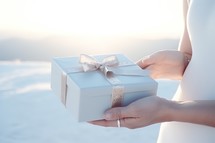 gift box in the hands of a woman on the background of the winter landscape