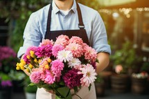 Male florist holding a bouquet of flowers in his hands
