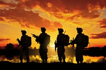 Silhouette of soldiers on the background of the setting sun.